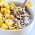 Tigela de aveia e abacaxi coberta com coco torrado