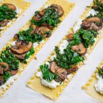 Rolos de massa recheados com cogumelos e couve em molho cremoso de couve-flor e queijos